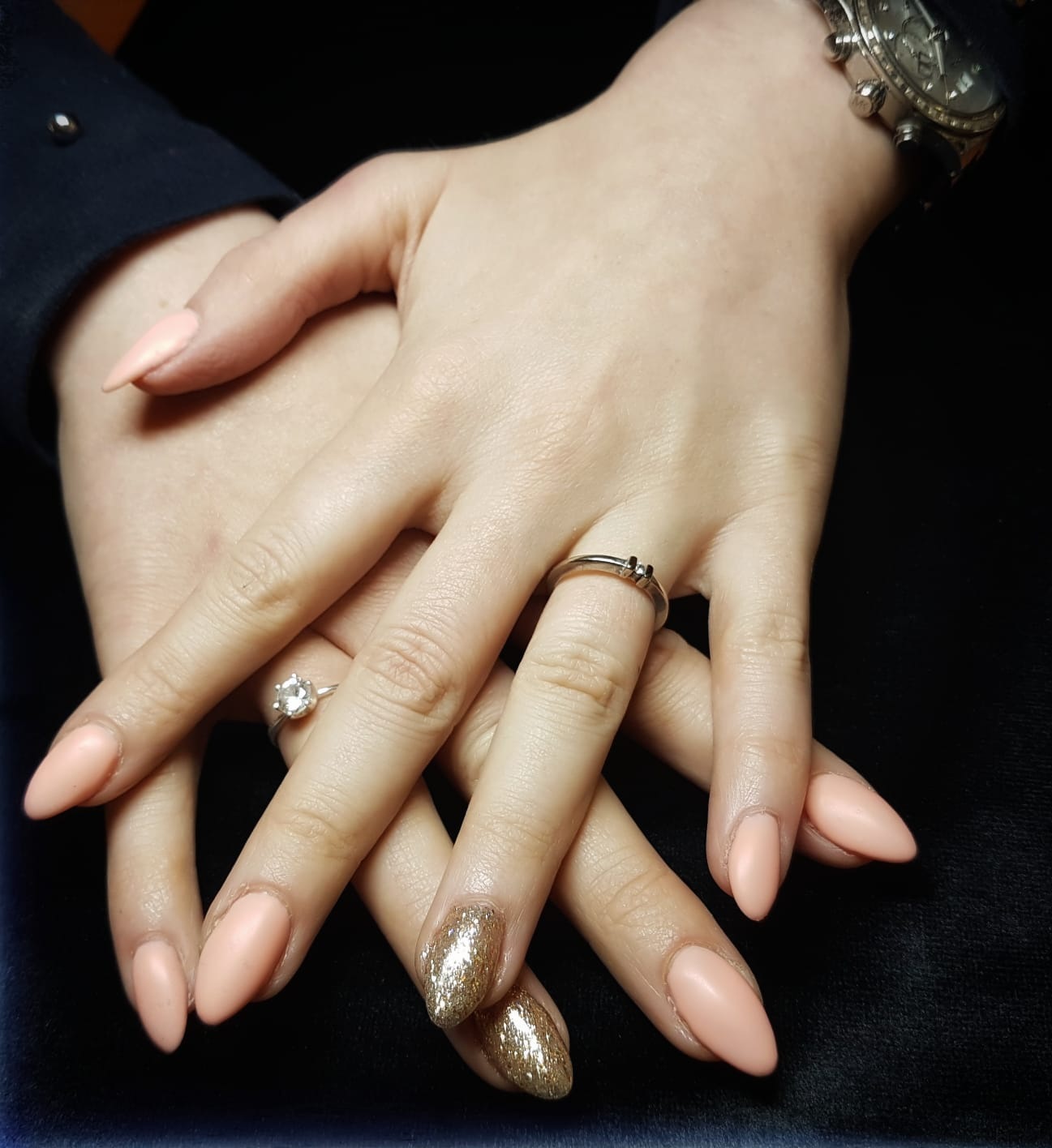 Lange amandelvormige nagels in zacht nude met één gouden glitternagel